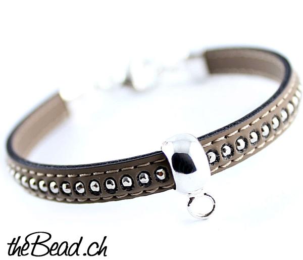 taupe farbenes lederarmband mit metallaplikationen und charm träger in silber aus 925 für karabiner